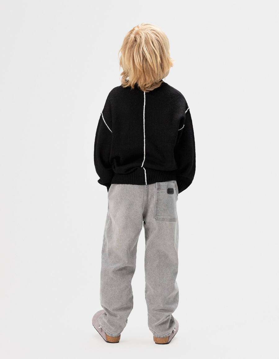 maglione nero in maglia da bambino con tasca sul petto