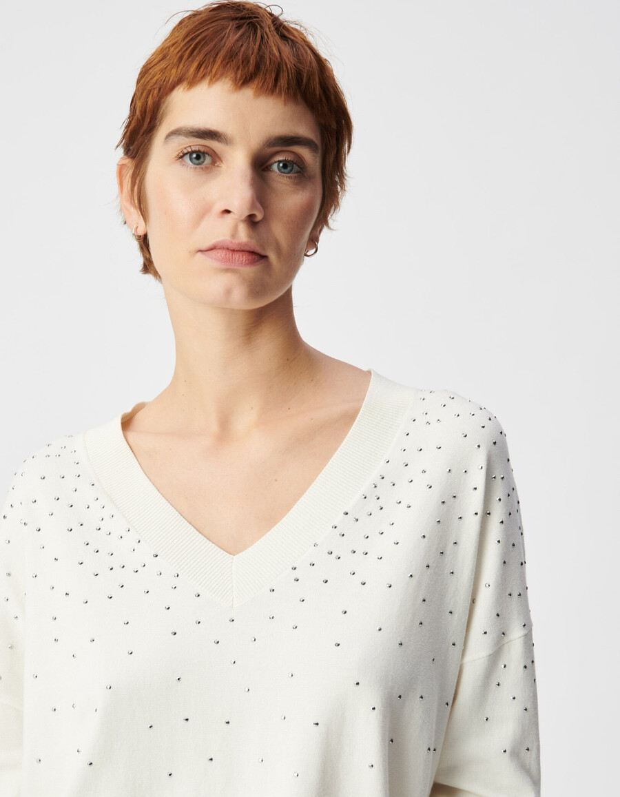 maglione bianco da donna lavorato a maglia con scollo a v e borchie